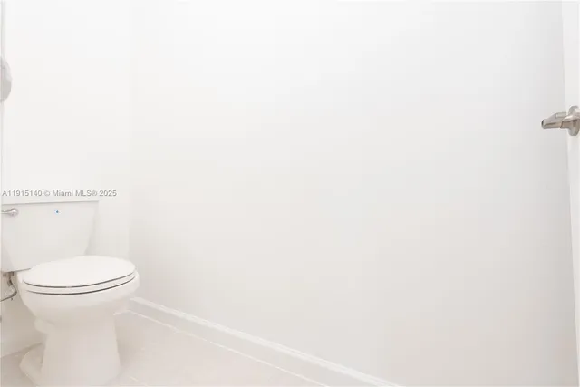 a white toilet sitting next to a white wall