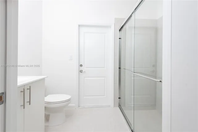 a bathroom with a shower a toilet and a sink