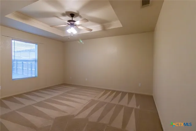 an empty room with a window and a ceiling fan