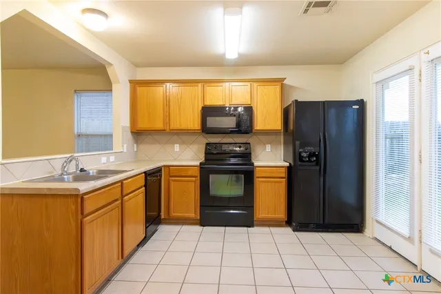 a kitchen with granite countertop a refrigerator and a sink