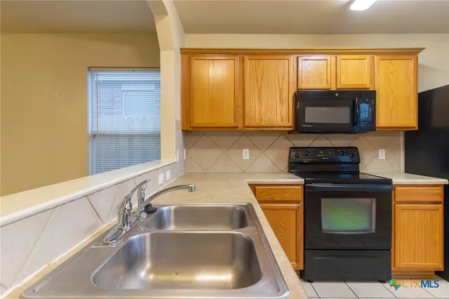 a kitchen with a sink a stove and a microwave