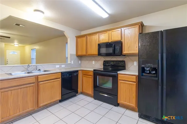 a kitchen with stainless steel appliances granite countertop a refrigerator sink and stove