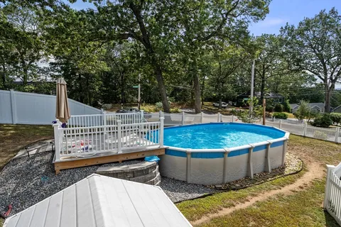 a view of a swimming pool with a patio and fire pit