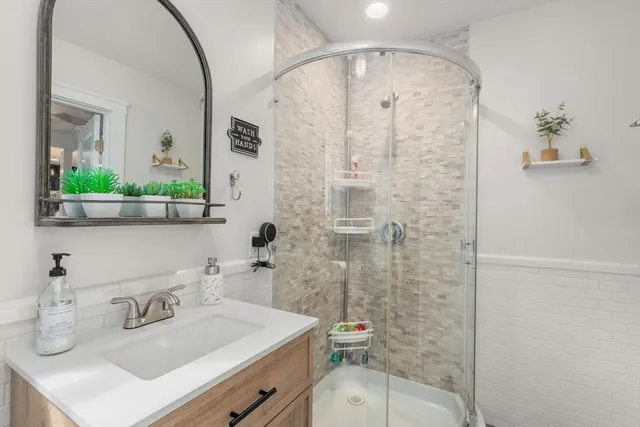 a bathroom with a sink a toilet and shower