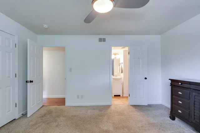 a view of an empty room with closet and a window