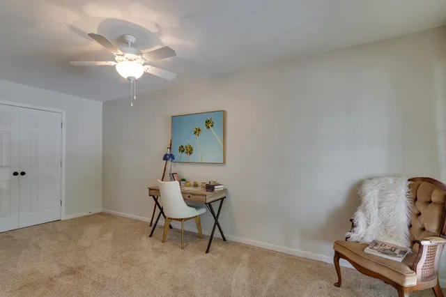 a view of a workspace with furniture and a chandelier fan