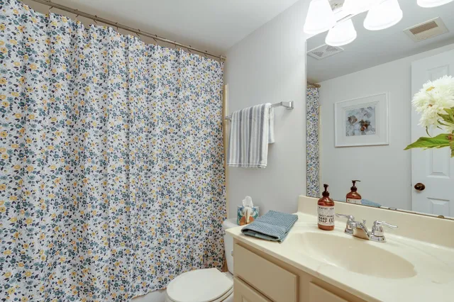 a bathroom with a sink toilet and mirror