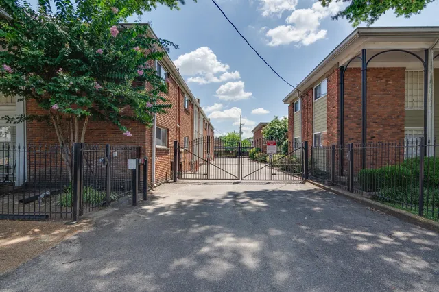 a view of a house with a small yard and floor to ceiling window and wooden fence