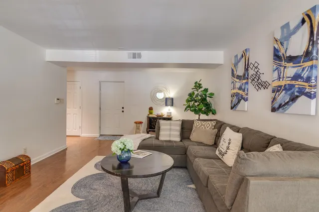 a living room with furniture and a wooden floor