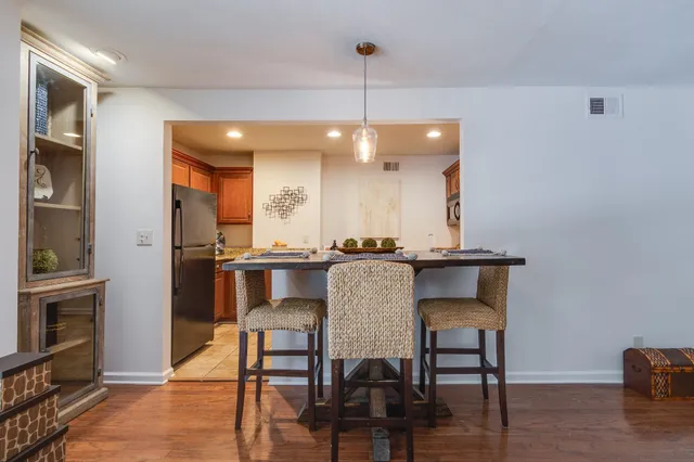 a kitchen with a table chairs refrigerator and oven