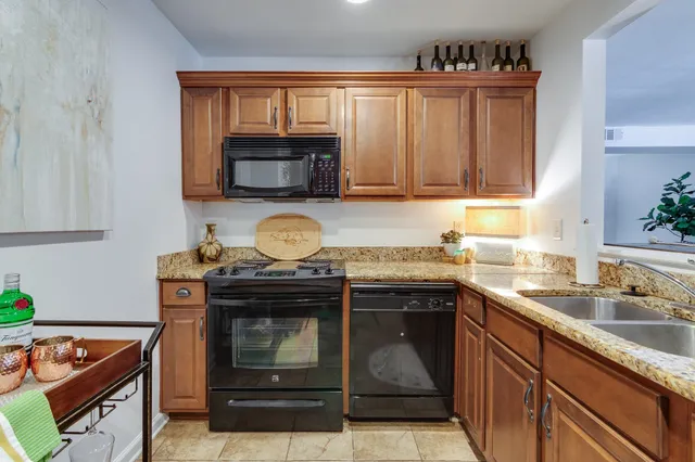a kitchen with granite countertop a sink stove and microwave