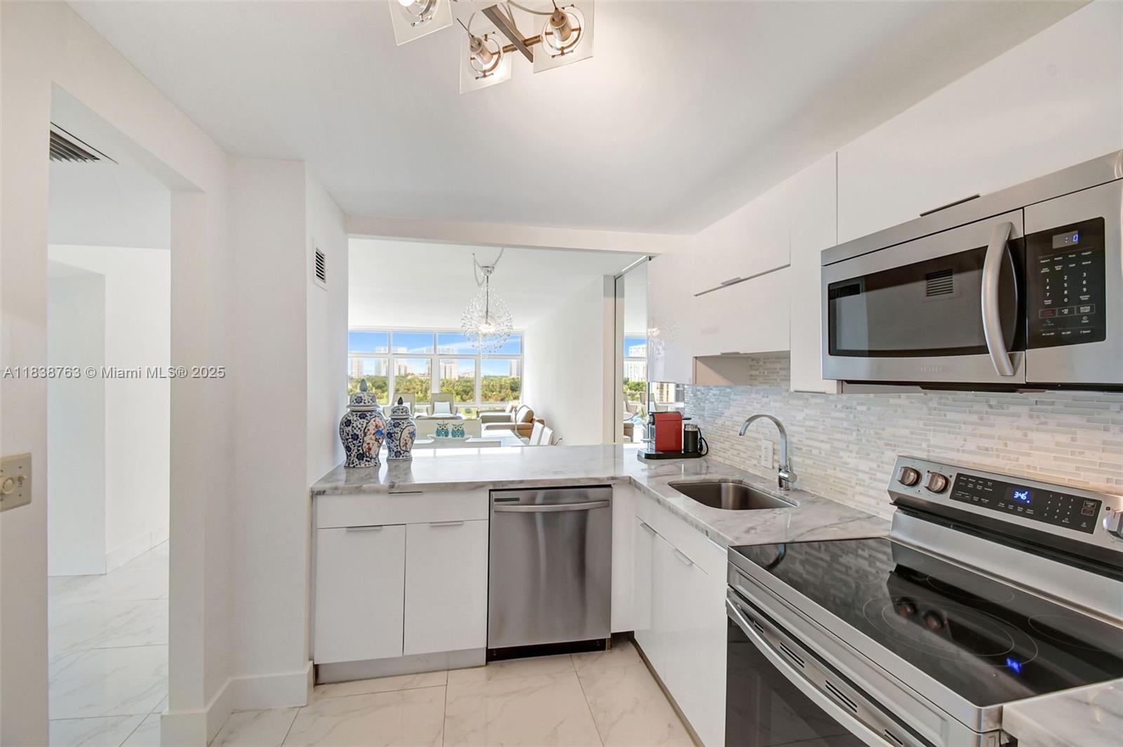 20100 West Country Club Drive, Unit 1005 Aventura, FL 33180 - Photo 10 of 36 a kitchen with a sink stove and microwave
