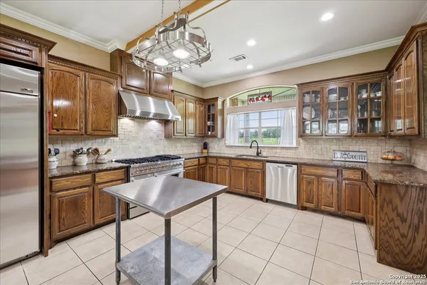 a kitchen with stainless steel appliances granite countertop a stove sink and cabinets