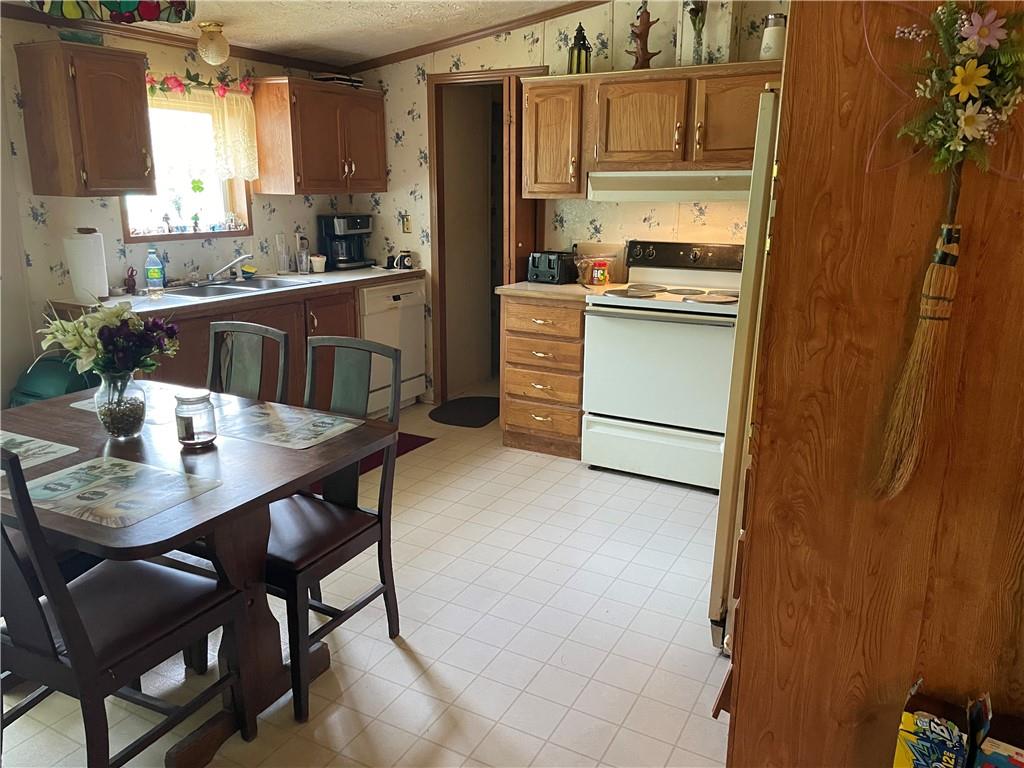 45-47 Ray Road Greenville, PA 16125 - Photo 11 of 15 a kitchen with a table chairs refrigerator and cabinets