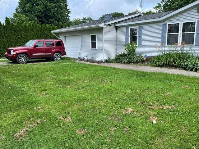 a front view of a house with a garden and yard