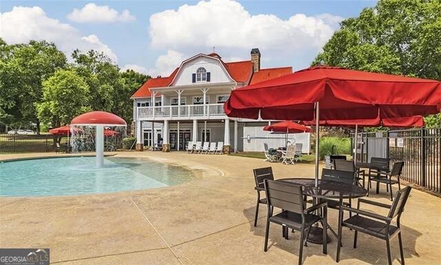 428 River Walk Covington, GA 30014 - Photo 4 of 6 a view of a swimming pool with a table and chairs under an umbrella