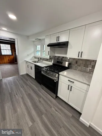 a kitchen with granite countertop a stove a sink and a refrigerator