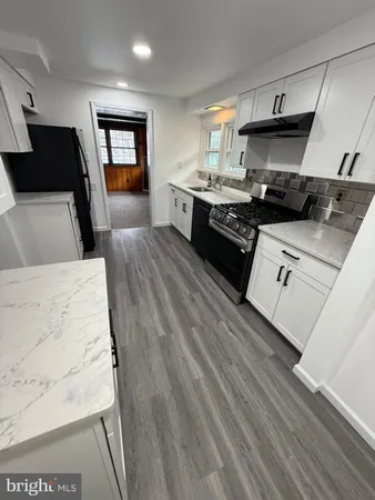 a kitchen with stainless steel appliances kitchen island granite countertop a stove a sink and a refrigerator