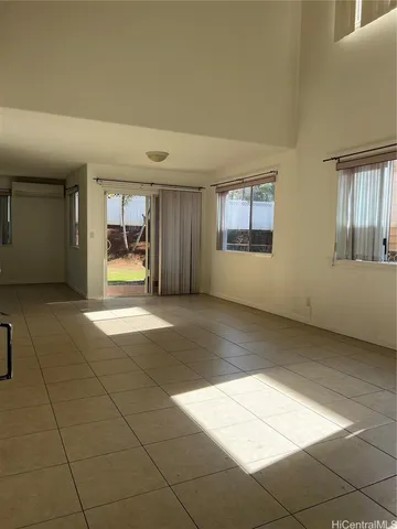 a view of an empty room with a fireplace and a window