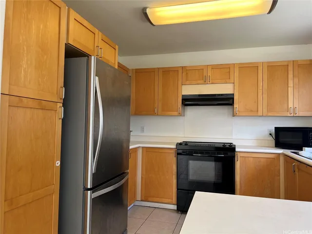 a kitchen with stainless steel appliances granite countertop a refrigerator a stove and a sink