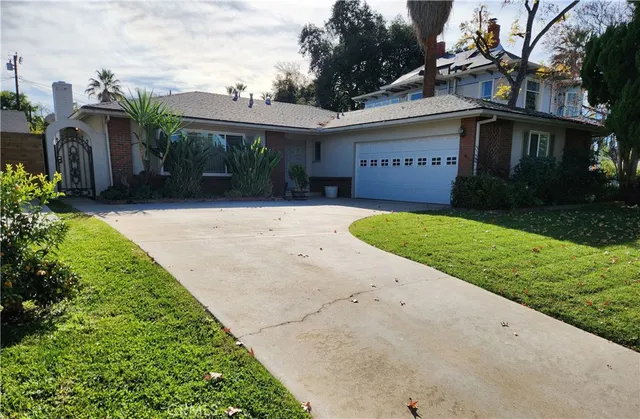 a view of a house with a yard and potted plants