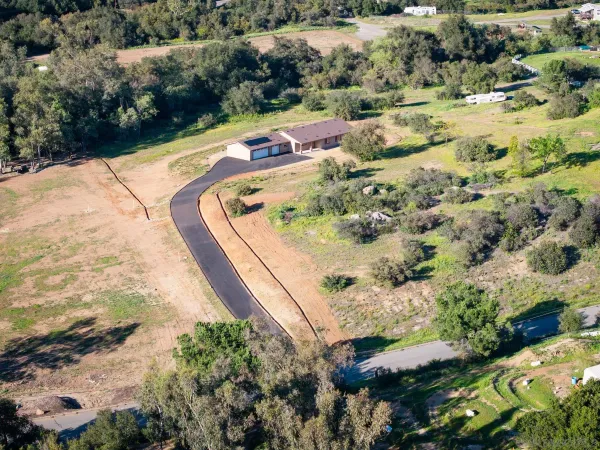an aerial view of ocean beach and residential house with swimming pool