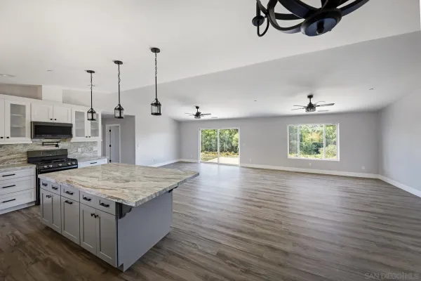 a kitchen with stainless steel appliances granite countertop a stove oven and a wooden floors
