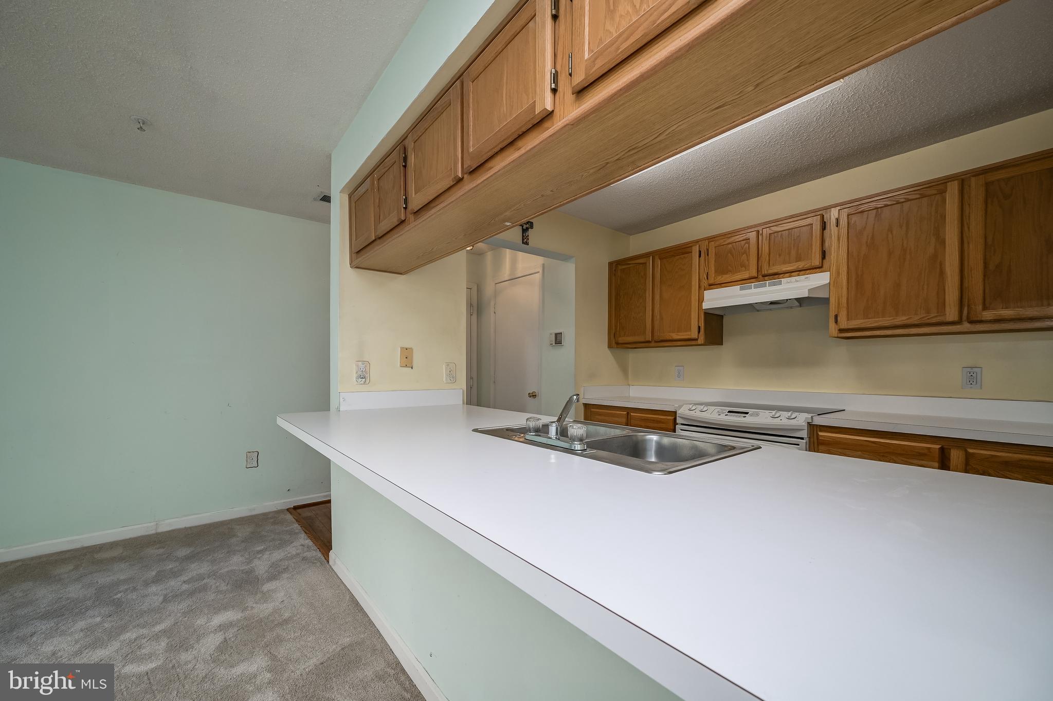 14202 Valleyfield Drive, Unit 338 Silver Spring, MD 20906 - Photo 18 of 38 a kitchen with stainless steel appliances a sink a stove and cabinets