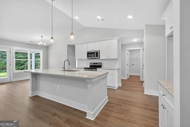 a large kitchen with stainless steel appliances kitchen island a large counter top and a sink