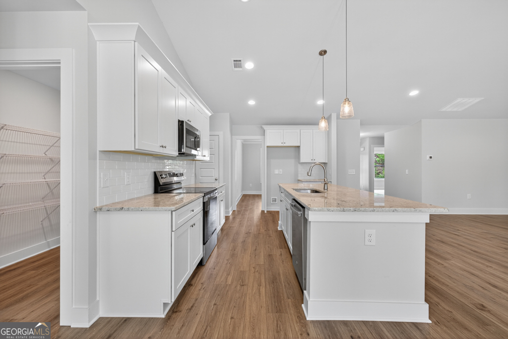 435 Watson Road Winder, GA 30680 - Photo 12 of 36 a large kitchen with stainless steel appliances kitchen island a large counter top and a sink
