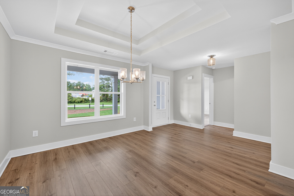 435 Watson Road Winder, GA 30680 - Photo 4 of 36 a view of an empty room with wooden floor kitchen view and a window