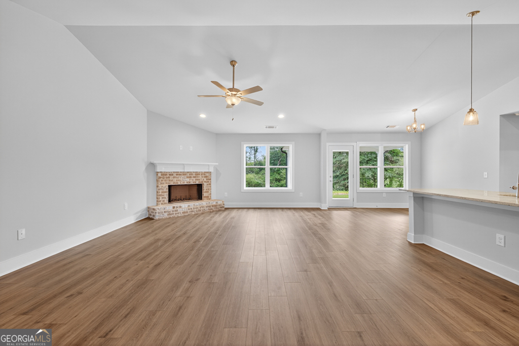 435 Watson Road Winder, GA 30680 - Photo 7 of 36 an empty room with wooden floor fireplace and windows