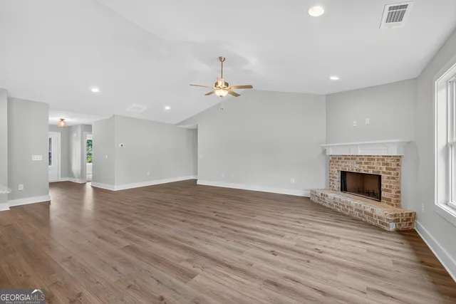 a view of kitchen with granite countertop stainless steel appliances cabinets a sink and a wooden floor