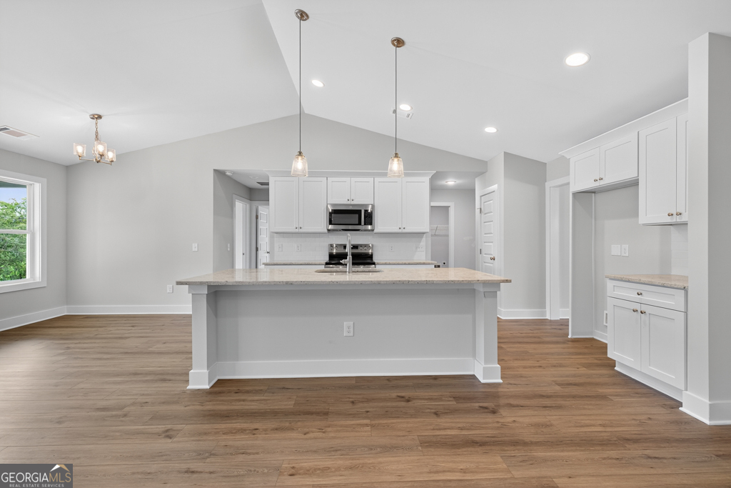 435 Watson Road Winder, GA 30680 - Photo 10 of 36 a view of kitchen with granite countertop stainless steel appliances cabinets a sink and a wooden floor