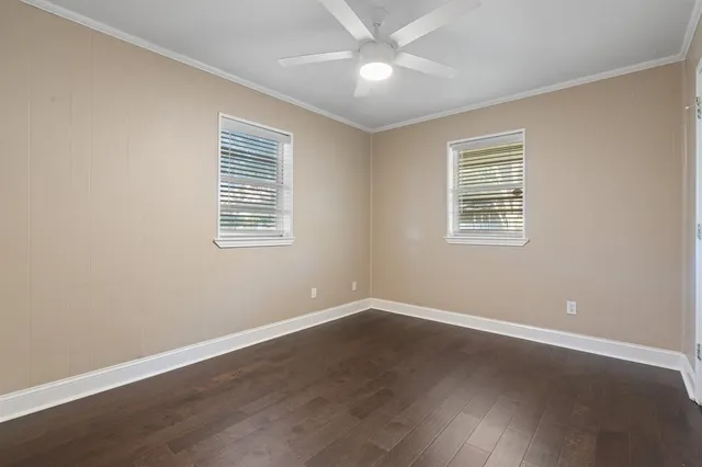 a view of an empty room with a window and a ceiling fan