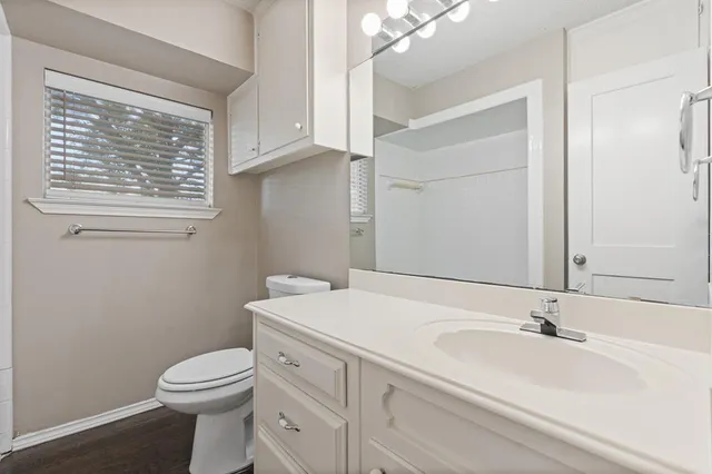 a view of an empty room with a sink and wooden floor