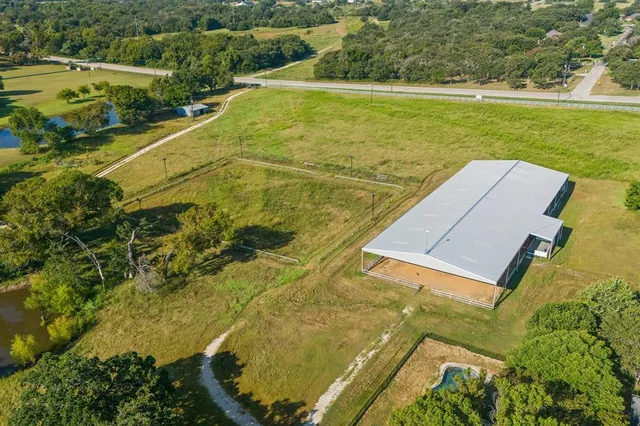 an aerial view of residential houses with outdoor space and trees
