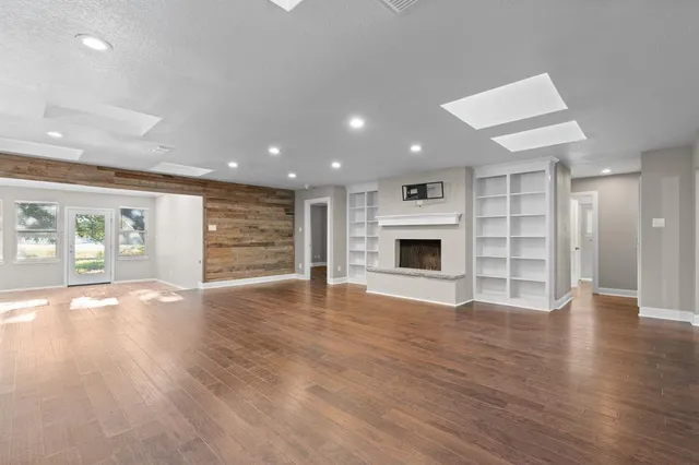 an empty room with wooden floor and fireplace