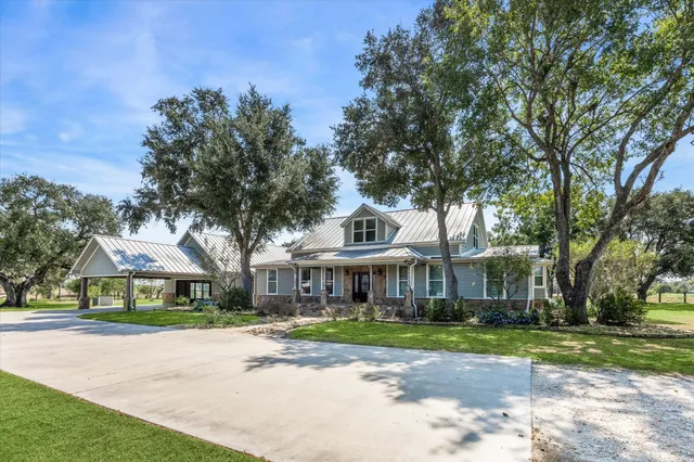 a front view of a house with a yard and potted plants