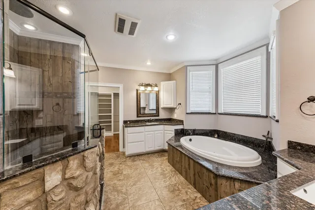 a bathroom with a granite countertop sink mirror bathtub and toilet