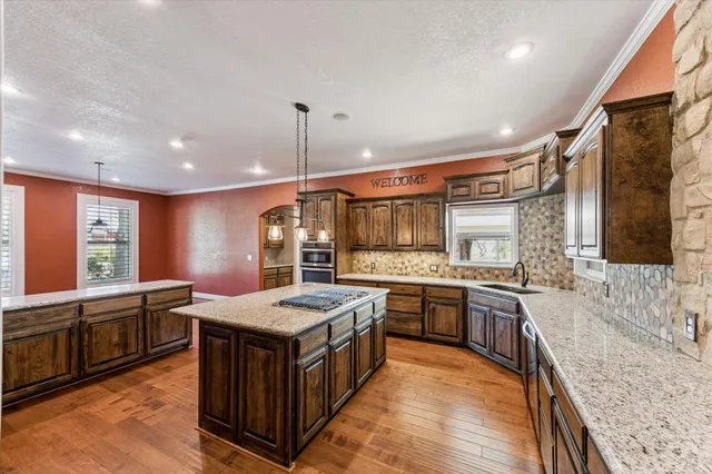 a large kitchen with stainless steel appliances granite countertop a sink and a stove