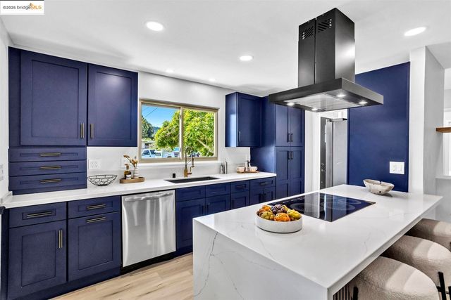 a kitchen with a sink a stove and wooden cabinets