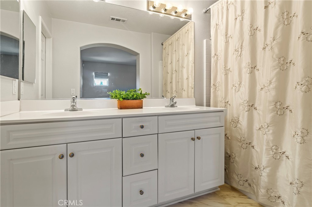 1339 Castledale Street Riverside, CA 92501 - Photo 24 of 32 a bathroom with a double vanity sink and a mirror