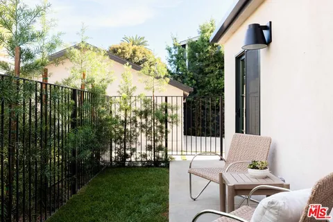 a view of backyard with a table and chairs and iron fence