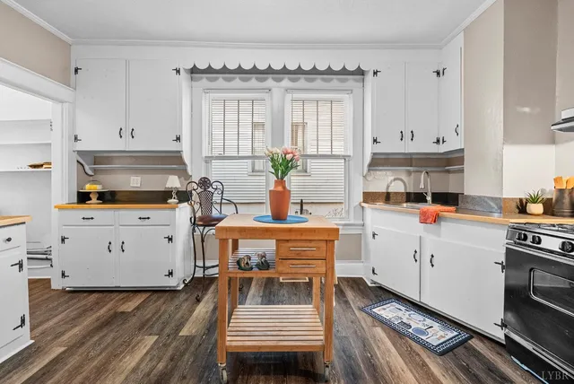 a kitchen with a white stove top oven and white cabinets