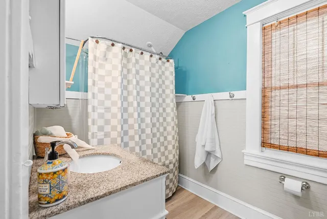 a bathroom with a granite countertop sink and a mirror
