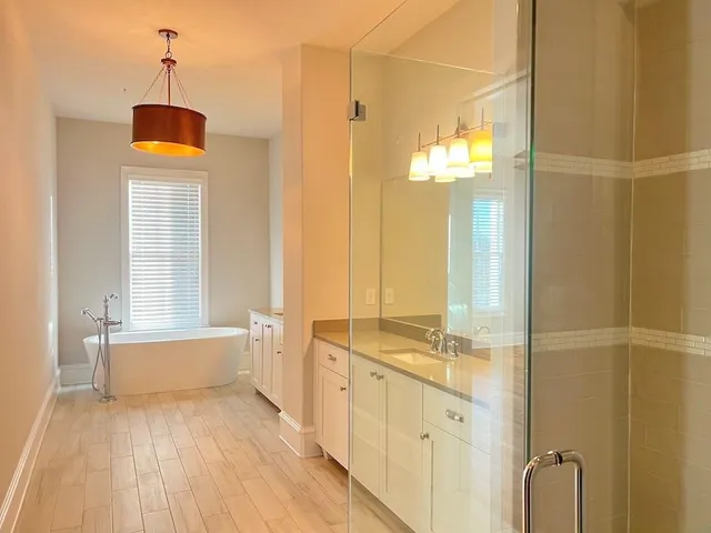 a bathroom with a double vanity sink a mirror and a bathtub