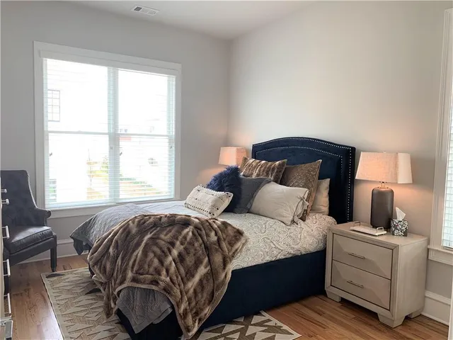a bedroom with a bed and wooden floor