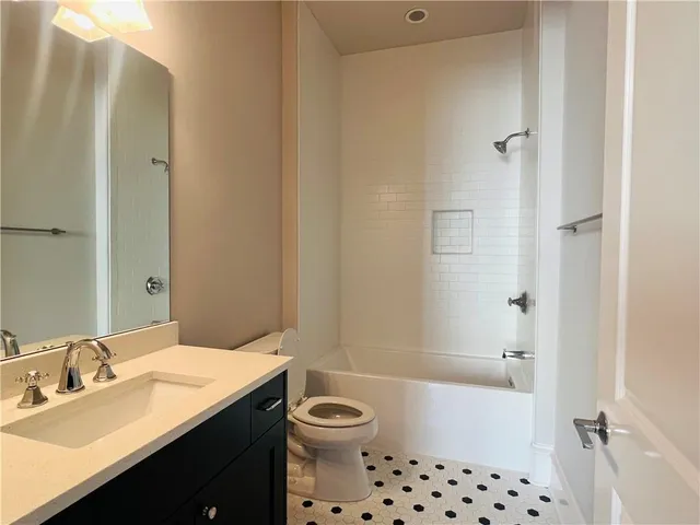 a bathroom with a bathtub shower sink vanity and a toilet