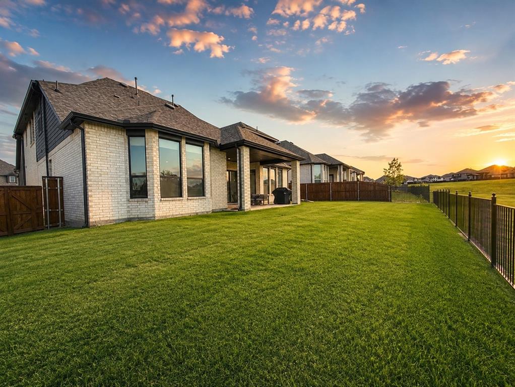 2150 Charming Frg Road Forney, TX 75126 - Photo 33 of 40 Expansive rear yard featuring a large lawn, brick exterior, and a covered patio